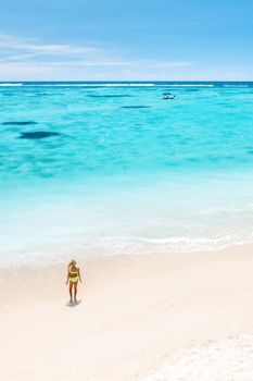 A little girl stands on Le Morne beach in the Indian Ocean on the island of Mauritius.