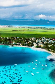 Aerial picture of the east coast of Mauritius Island. Beautiful lagoon of Mauritius Island shot from above. Boat sailing in turquoise lagoon.