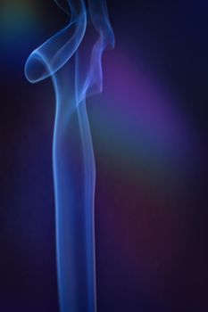 A vertical shot of smoke in colorfull backlight with a blue note