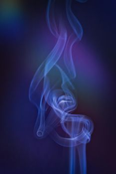 A vertical shot of smoke in colorfull backlight with a blue note