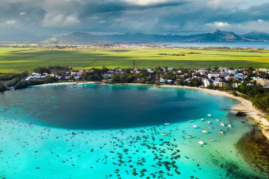 Top view of the Blue Bay lagoon of Mauritius. A boat floats on a turquoise lagoon.
