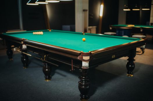 Billiard table with green surface and balls in the billiard club