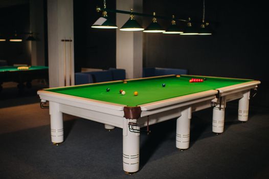 placing snooker balls on a green billiard table.