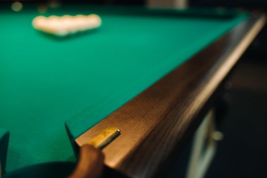 The oak decorative leg of a billiard table looks expensive.