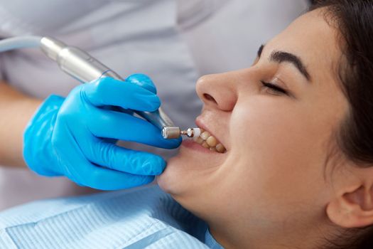 Young woman getting her teeth polished in modern dental clinic