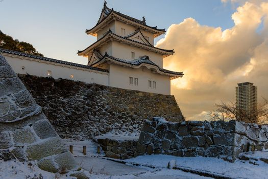 Sunrise clouds over historic Japanese castle and modern luxury apartment in snow. High quality photo