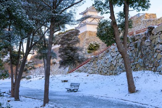 Snow covered bench at Japanese castle park on winter day. High quality photo