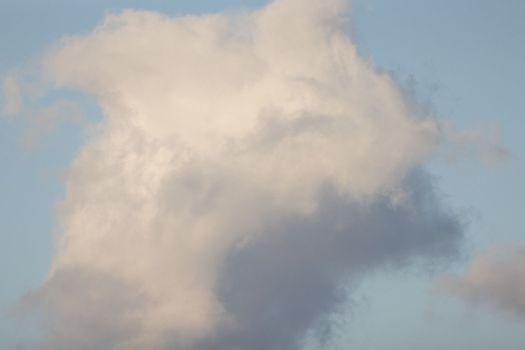 Fluffy white cloud against blue sky background. High quality photo