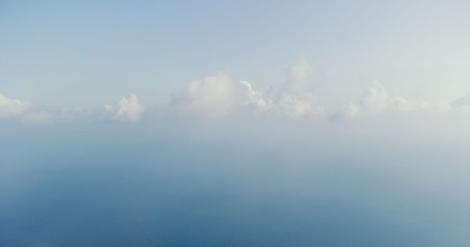 Blue sky with white clouds moving panorama summer. Sea in light of day aerial view of drone slide forward. Small waves on sea. Sunny sunset over the sea. Sun way. Horizon