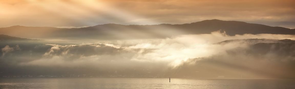 A photo of Sunset, ocean and mountains.