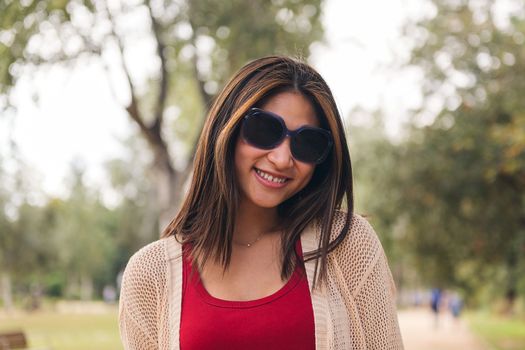 young asian woman with sunglasses smiling looking at camera, concept of youth and beauty, copy space for text