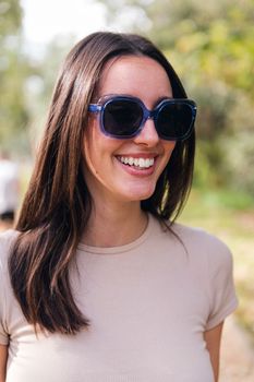 portrait of a young caucasian woman with sunglasses smiling, concept of youth and beauty