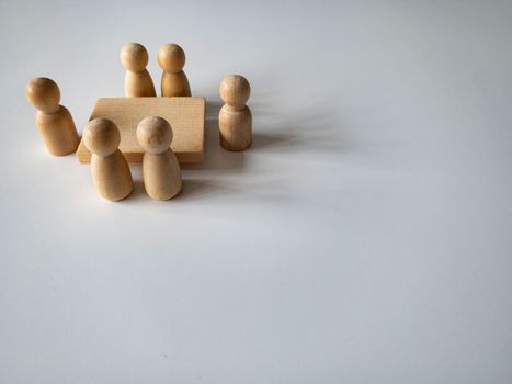 Wooden people figures having business meeting with customizable space for text. Business concept and copy space