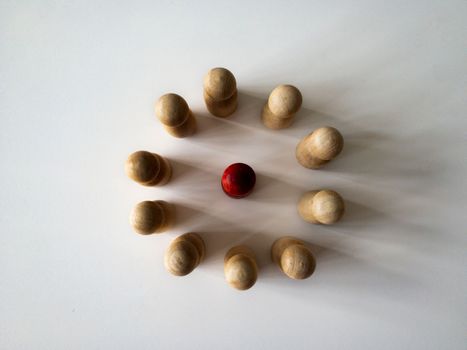 Top view of red wooden doll figure surrounded by other doll figure. Harassment concept.
