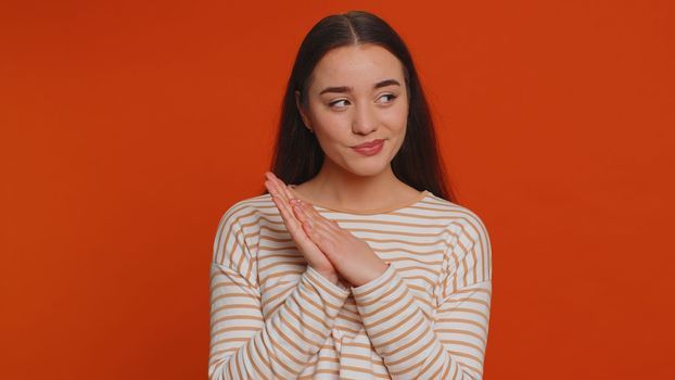 Sneaky cunning pretty woman with tricky face gesticulating and scheming evil plan, thinking over devious villain idea, cheats, revenge, jokes, pranks. Young girl isolated on red studio background