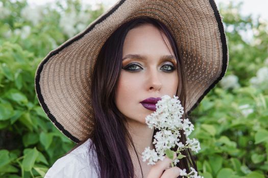 A fashionable girl with dark hair, a spring portrait in lilac tones in summer. Bright professional makeup