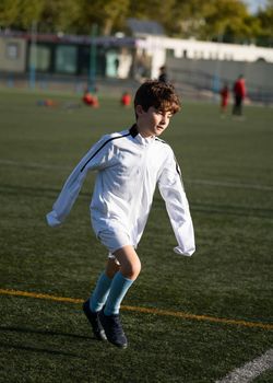 Kid player exercising before match on soccer field.Kids soccer football concept
