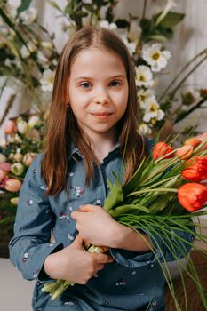 Two girls in a beautiful Easter photo zone with flowers, eggs, chickens and Easter bunnies. Happy Easter holiday