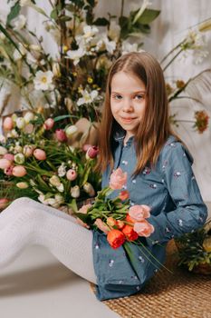 Two girls in a beautiful Easter photo zone with flowers, eggs, chickens and Easter bunnies. Happy Easter holiday