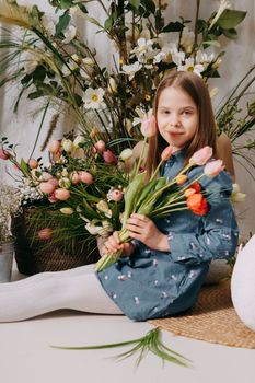 Two girls in a beautiful Easter photo zone with flowers, eggs, chickens and Easter bunnies. Happy Easter holiday