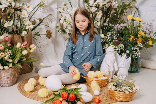 Two girls in a beautiful Easter photo zone with flowers, eggs, chickens and Easter bunnies. Happy Easter holiday
