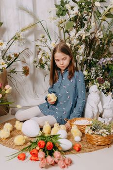 Two girls in a beautiful Easter photo zone with flowers, eggs, chickens and Easter bunnies. Happy Easter holiday