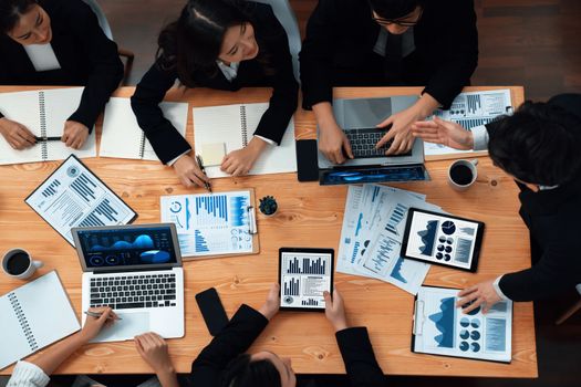 Top-view business team of financial data analysis meeting with business intelligence, report paper and dashboard on laptop for marketing strategy. Business people working together in office of harmony