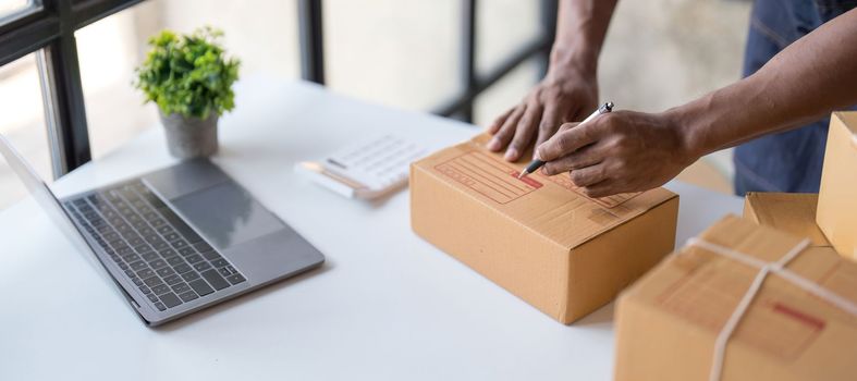 Online shopping young start small business in a cardboard box at work. The seller prepares the delivery box for the customer, online sales, or ecommerce