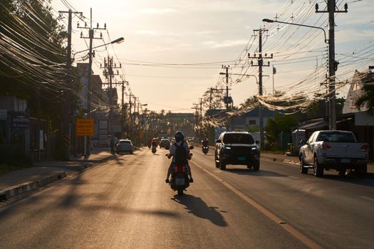 Atmospheric photo traffic on the street in Thailand during sunset. Koh Samui, Thailand - 09.15.2022