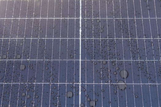 Green energy. Solar panels with raindrops close up. The use of waterproof solar panels in difficult environments, the production of green energy