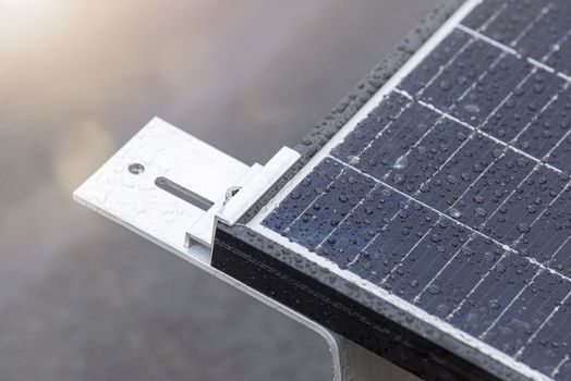 Bracket for mounting solar panels. Mounting a solar panel close-up on the roof of a residential building, water drops after rain, green energy production