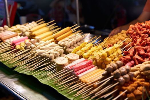A counter with different kinds of satey. Street food market in Thailand. food on a stick.