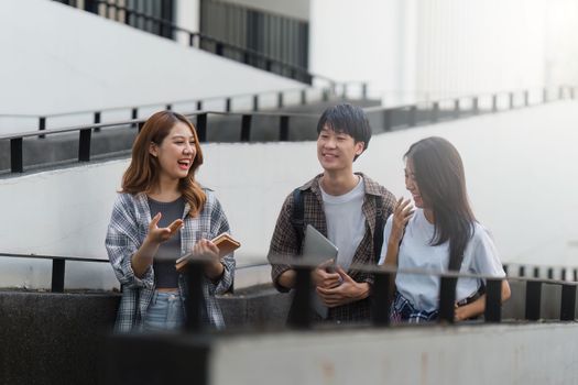 Beautiful young Asian woman college student with friends at outdoors. College student working on the college campus.