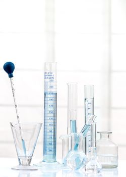 Set of laboratory glassware with blue liquid on white background. B