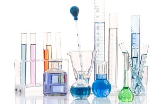 Laboratory equipment and color chemicals on white background