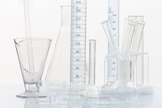 Set of laboratory glassware with blue liquid on white background. B