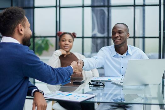 smiling diverse multiracial male business partners handshake close deal make agreement after successful negotiation