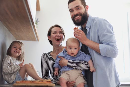 Young family with daughter and son in the kitchen