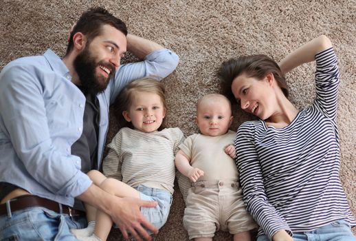 happy family mother father and kids at home. laying