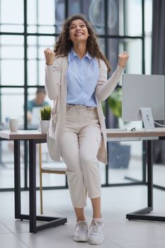 Excited young girl celebrating success business achievement result, looking camera