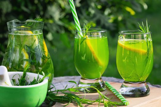 Homemade summer refreshing tarragon lemon drink on patio table.