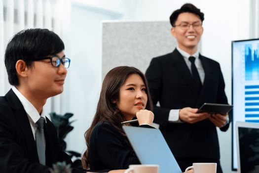 Confidence and asian businessman give presentation on financial analyzed by business intelligence in dashboard report to other people in board room meeting to promote harmony in workplace.