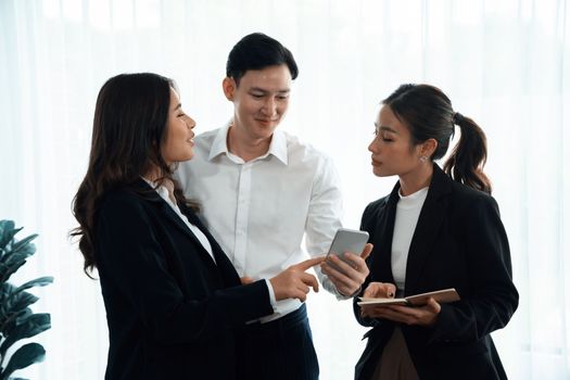 Mentor, manager advice younger colleagues in workplace. Businesspeople discussing or planning financial project strategy, talking together for harmony and strong teamwork in office concept.