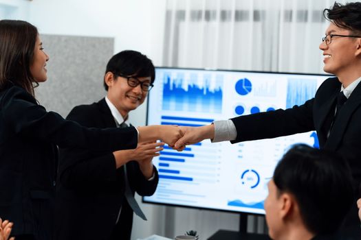 Businesspeople shake hand after successful agreement or meeting. Office worker colleague handshake with business team leader manager for strong teamwork in office to promote harmony and unity concept.