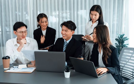 Harmony in office concept as business people analyzing dashboard paper together in workplace. Young colleagues give ideas at manager desk for discussion or strategy planning about project.