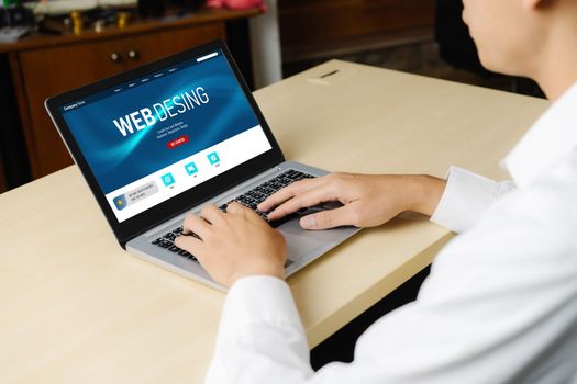 Business person or office worker using laptop computer while sitting at desk.