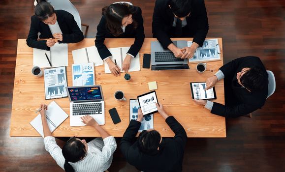 Top-view business team of financial data analysis meeting with business intelligence, report paper and dashboard on laptop for marketing strategy. Business people working together in office of harmony