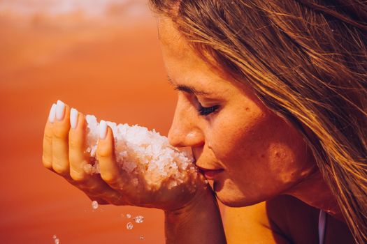 Salt mining. Salty pink lake with crystals of salt. Extremely salty pink lake, colored by microalgae with crystalline salt depositions