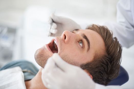 Checking that everything is fine...a young man at the dentist