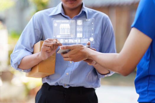 Close up of Asian Man signing his name by hand to accept a delivery package and a smartphone. logistical delivery concept.